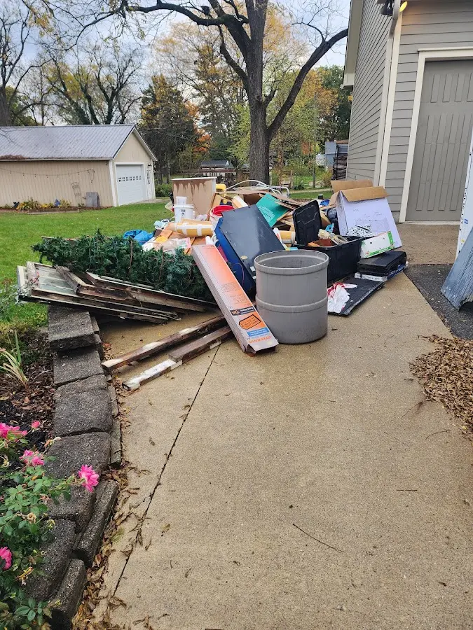 Dumpster being loaded with debris for Estate Cleanout Dumpster Rental in Monett